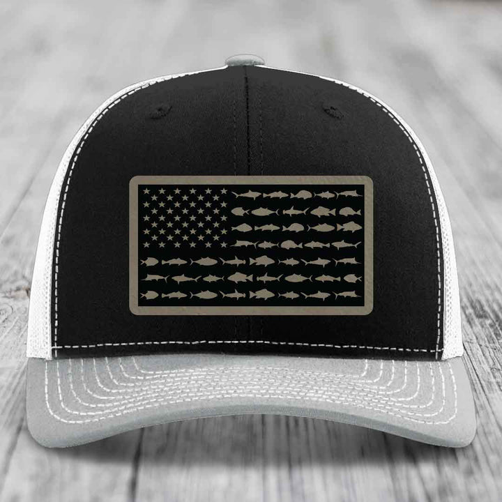 Black and white trucker hat with saltwater fish flag patch on front.