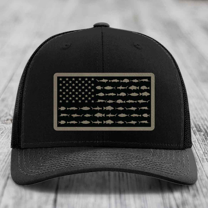 Black trucker hat with American flag patch made of saltwater fish silhouettes.