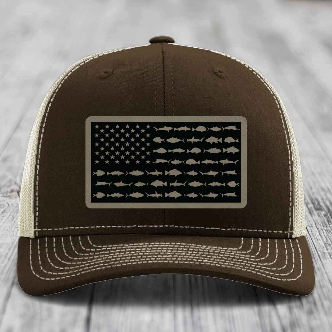 Brown trucker hat with white stitching and a patch featuring an American flag made of fish silhouettes.