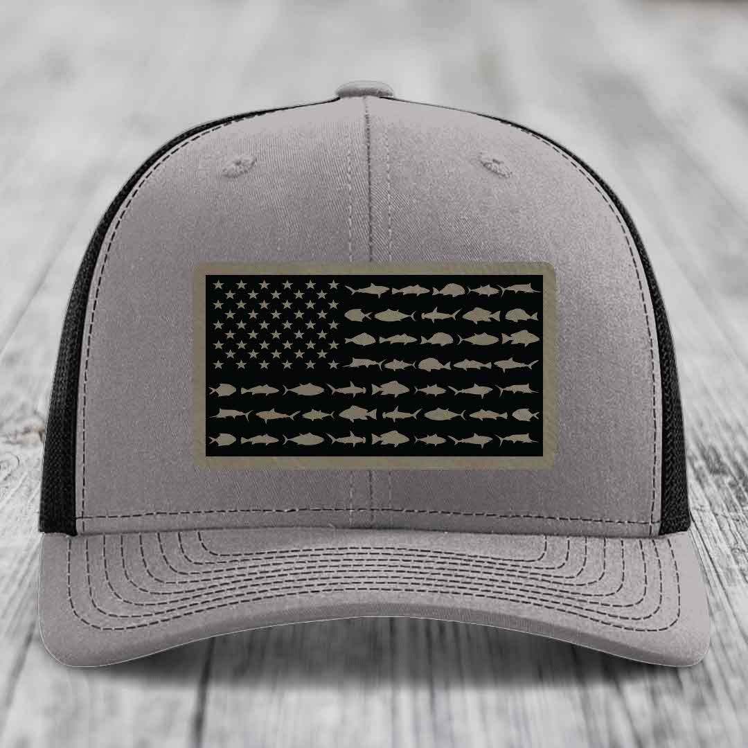 Grey trucker hat with black mesh back and a rectangular patch featuring an American flag design made of fish silhouettes.