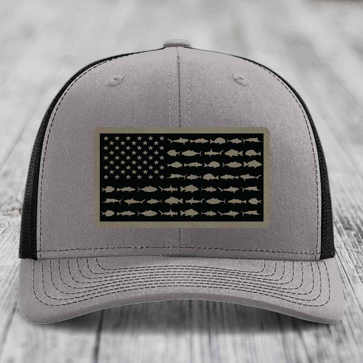 Grey trucker hat with black mesh back and a rectangular patch featuring an American flag design made of fish silhouettes.