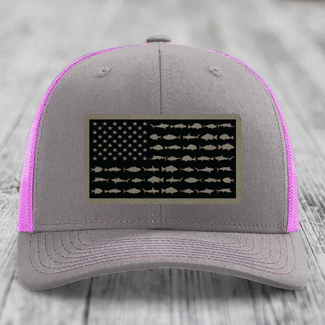 Grey trucker hat with pink mesh sides and a saltwater fish flag patch on front.