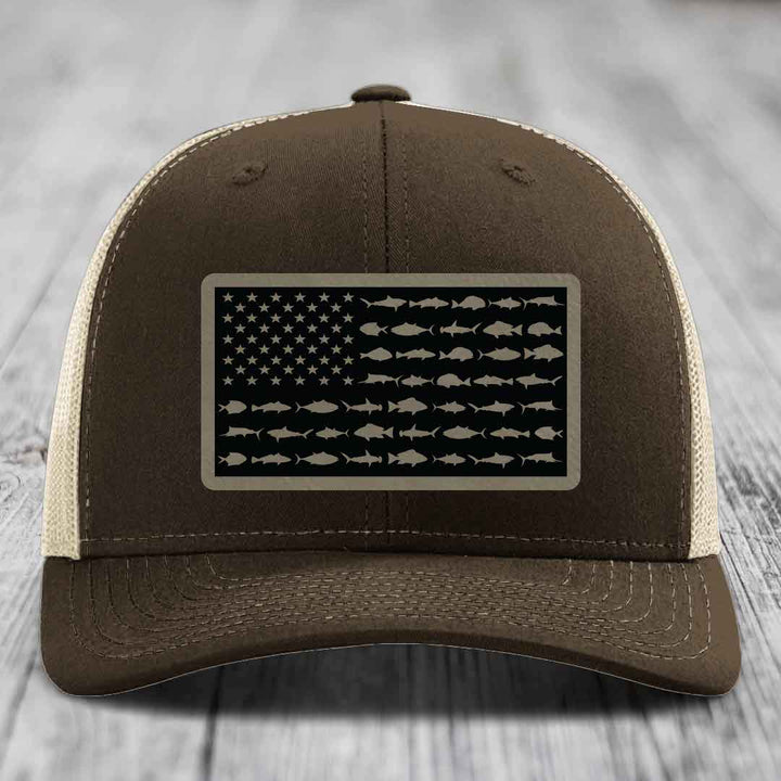 Brown trucker hat with American flag patch made of saltwater fish silhouettes.
