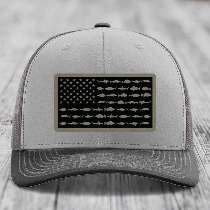 Grey trucker hat with black American flag patch featuring fish silhouettes instead of stars and stripes.