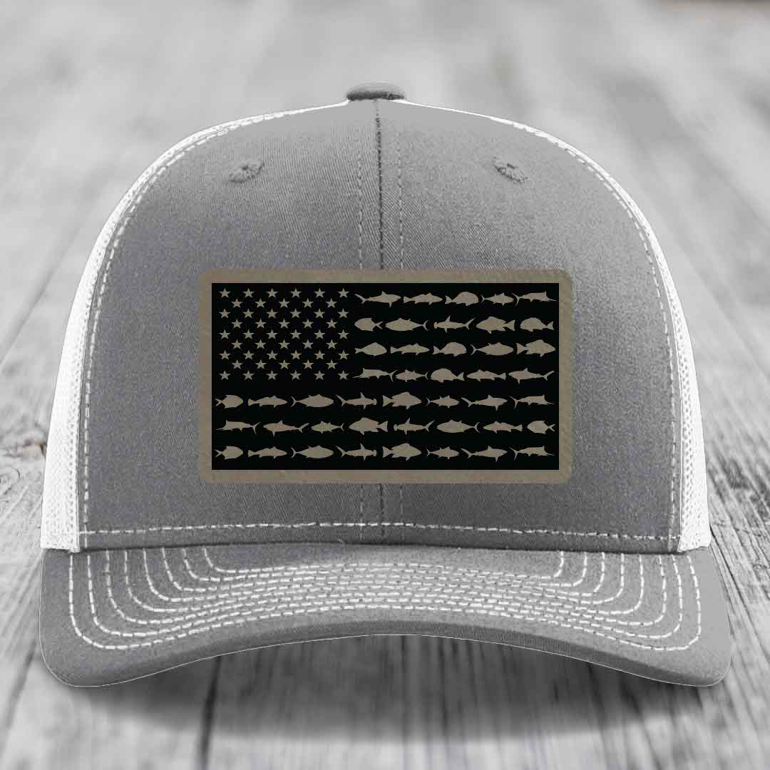 Grey trucker hat with white mesh back and stitched details, featuring a saltwater fish flag patch.