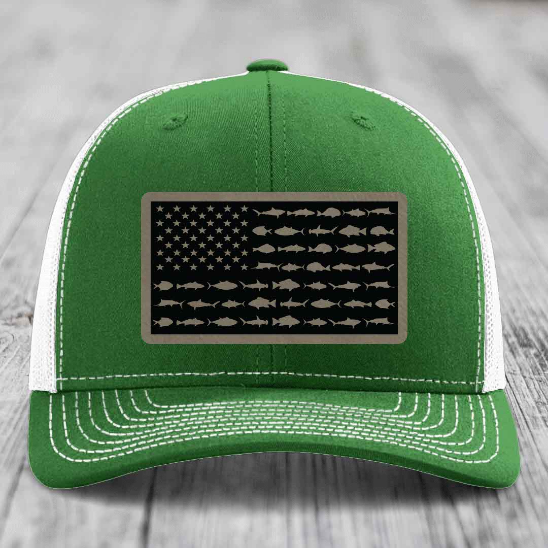 Green trucker hat with white mesh back and stitching, featuring a rectangular patch of an American flag made with fish silhouettes.