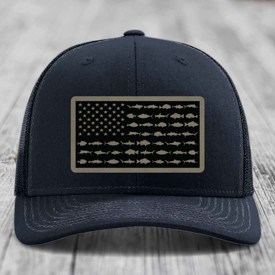 Black trucker hat with a tan leather patch featuring an American flag design made of fish silhouettes.
