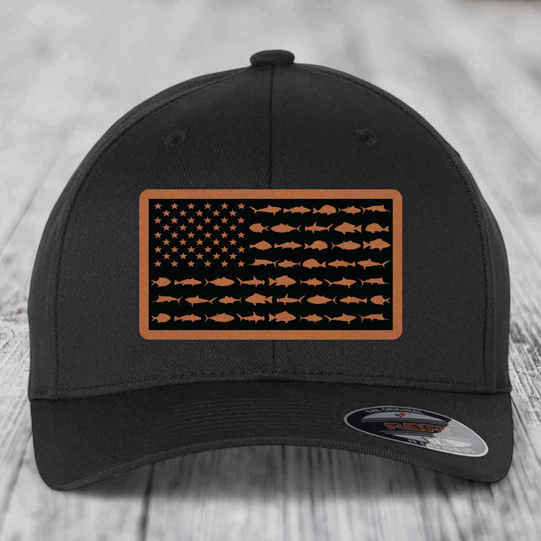Black baseball cap with rectangular leather patch featuring American flag design made of saltwater fish silhouettes in tan on black background.