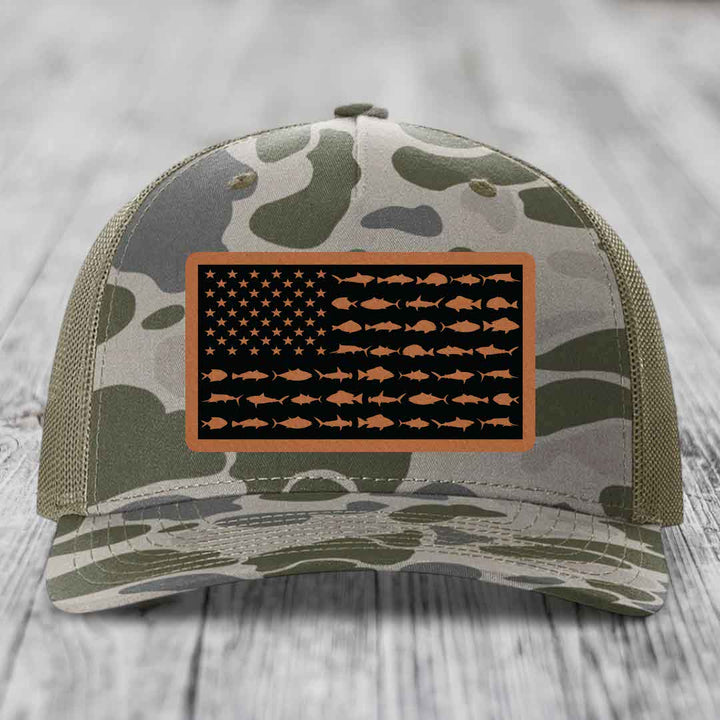 Camouflage trucker hat with American flag patch featuring fish silhouettes instead of stars and stripes.