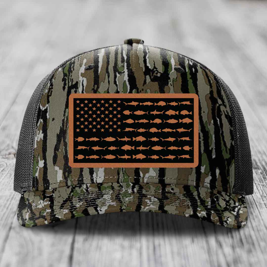 Camouflage trucker hat with American flag patch made of saltwater fish silhouettes in tan on black background.