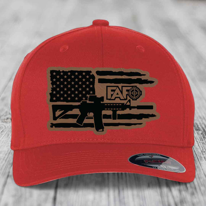 Red baseball cap with American flag and AR-15 graphic patch on front.