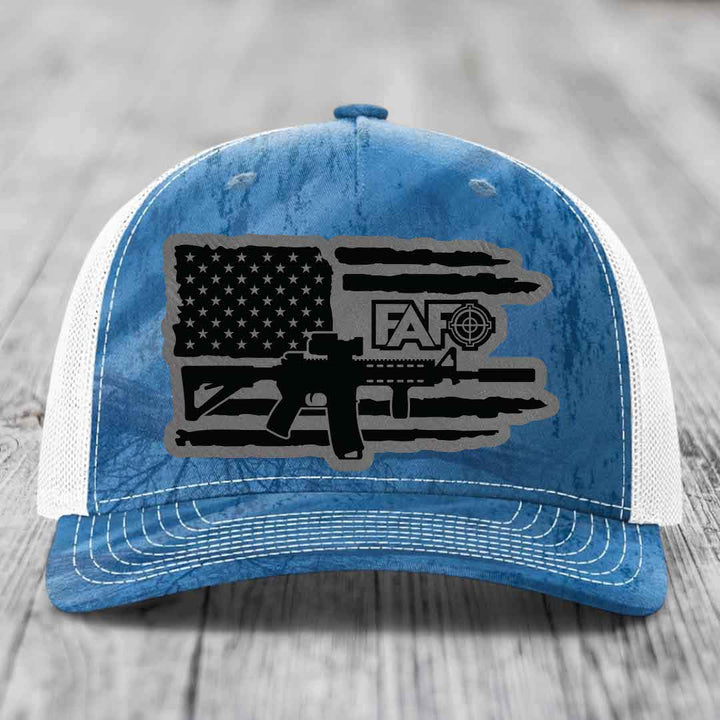 Blue and white trucker hat with American flag and AR-15 graphic patch.