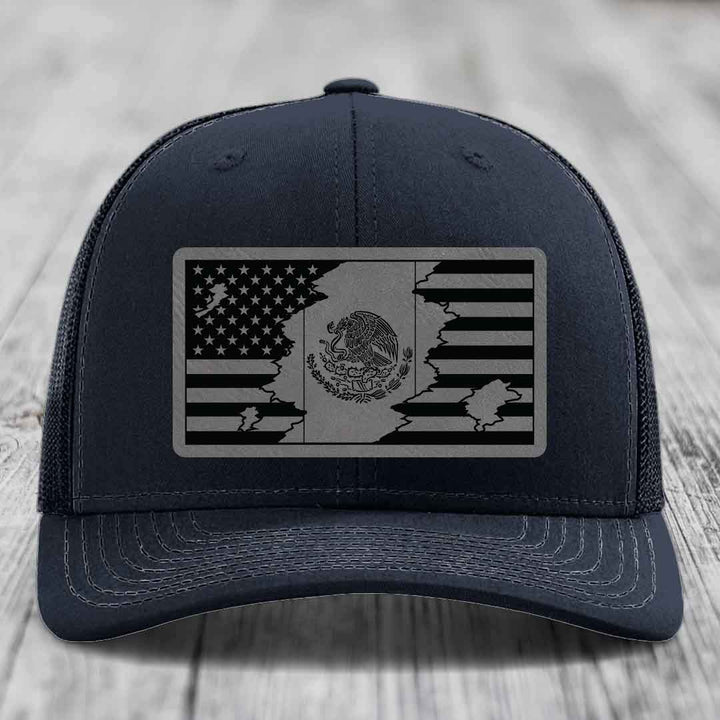 Black trucker hat with a black and grey American and Mexican flag patch on the front.