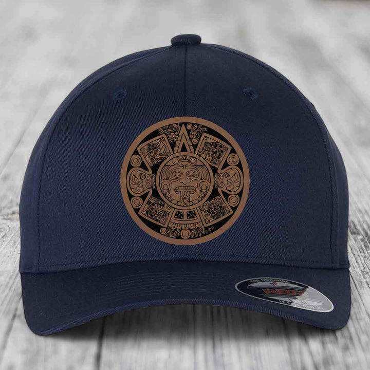 Dark blue baseball cap with Aztec calendar design patch on front.