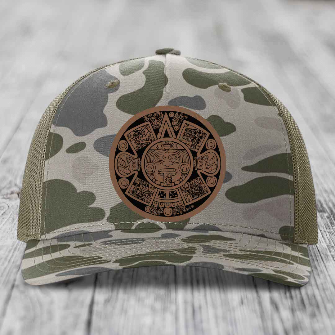 Camouflage trucker hat with Aztec calendar leather patch on front.