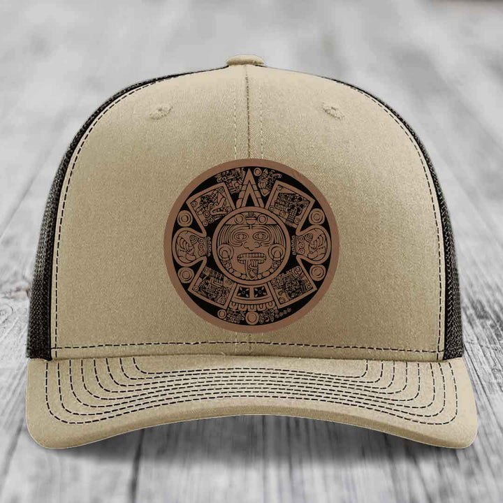 Beige trucker hat with brown Aztec calendar patch on front.