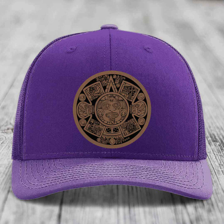 Purple trucker hat with Aztec calendar leather patch on front.