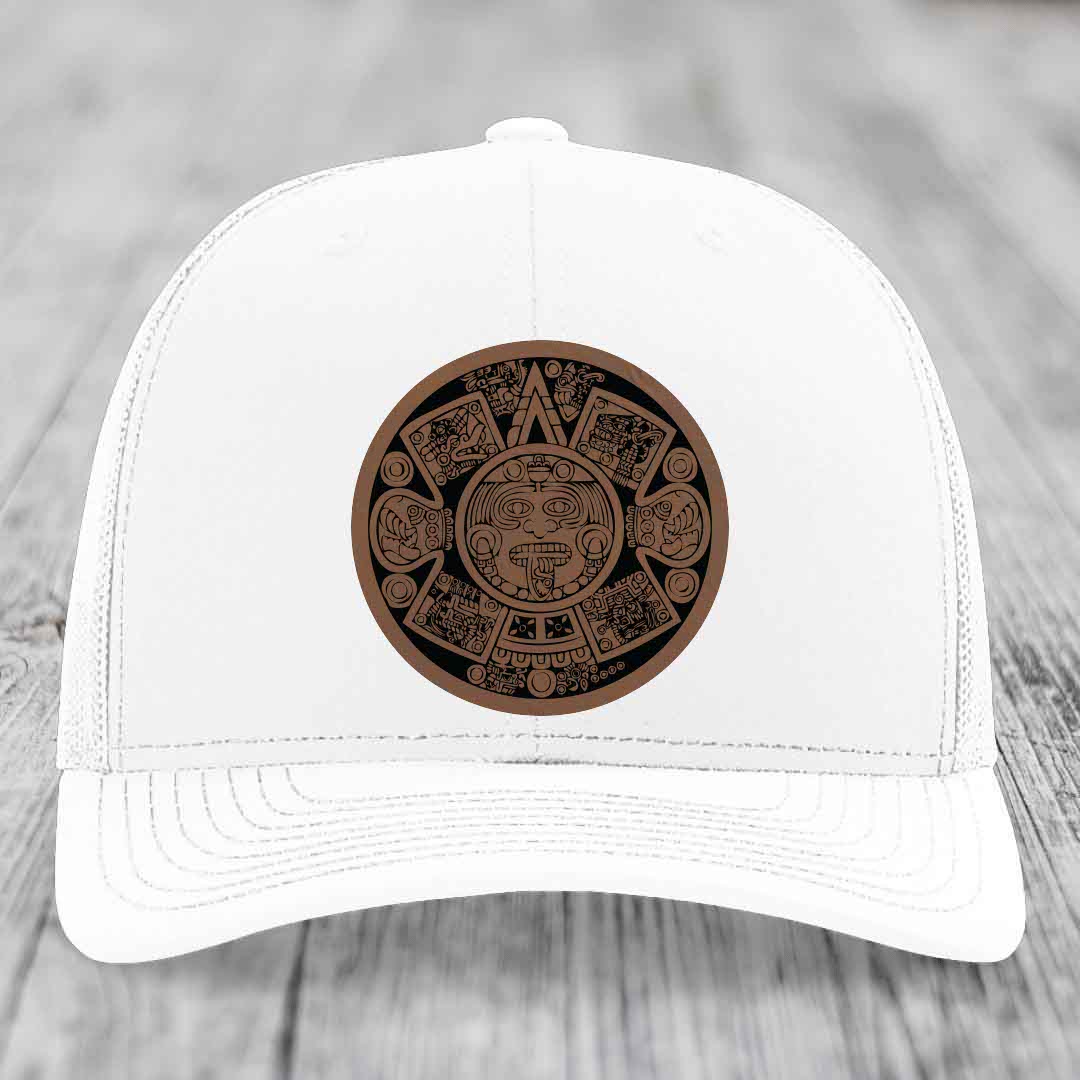 White trucker hat with brown Aztec calendar leather patch on front.
