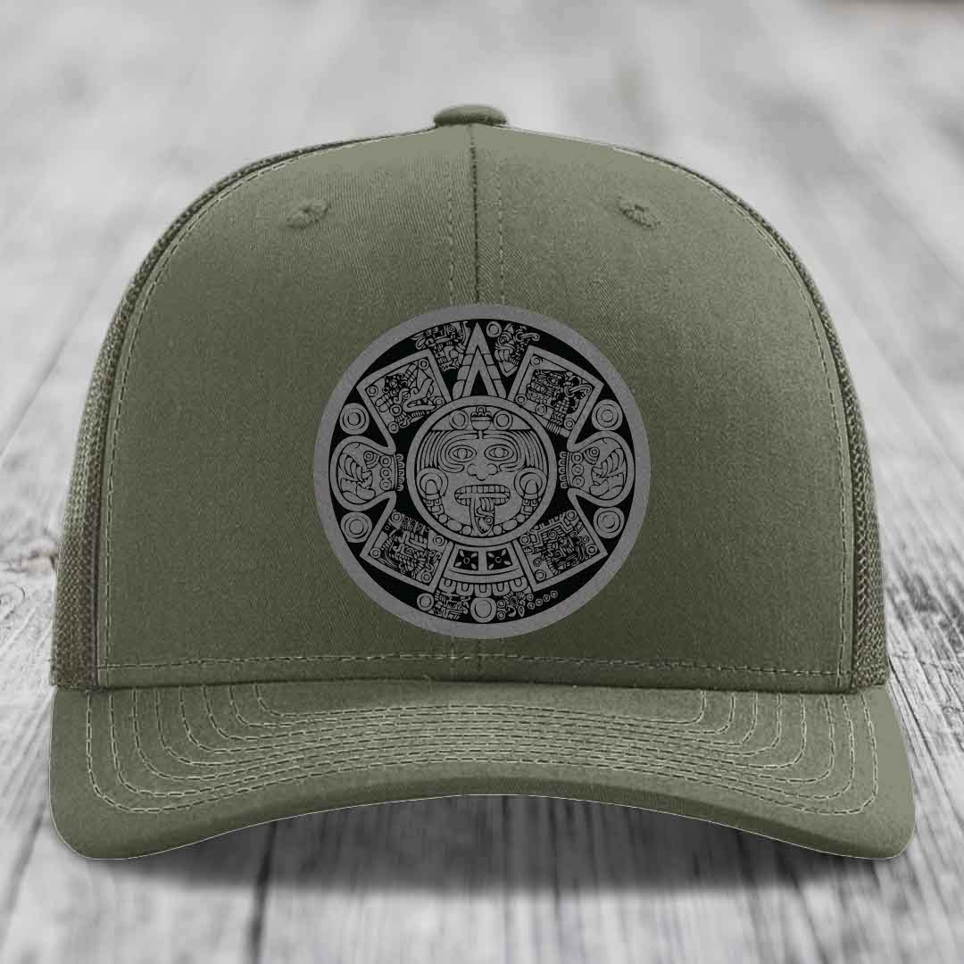 Olive green trucker hat with Aztec calendar patch on front.