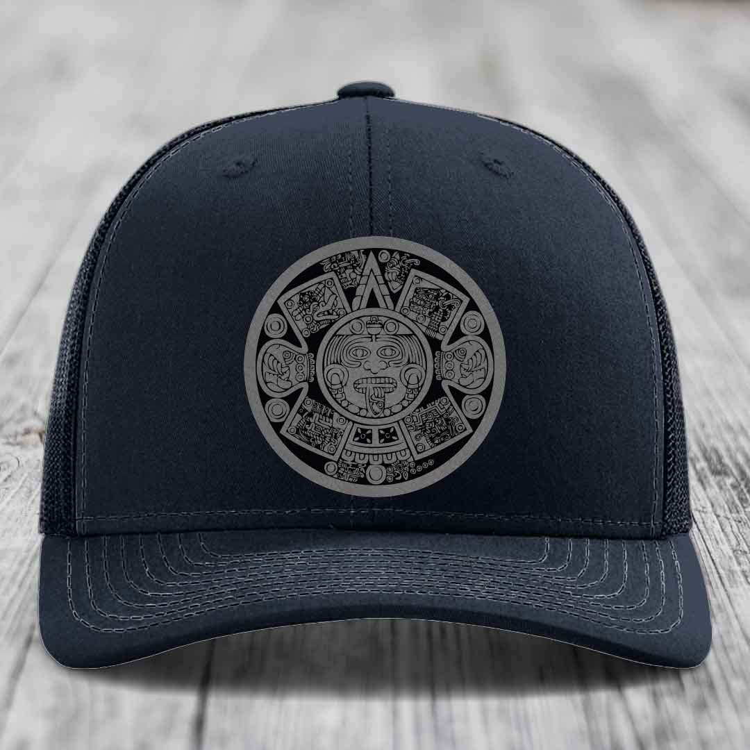 Black trucker hat with Aztec calendar design on front, featuring detailed face and symbols in gray outline.