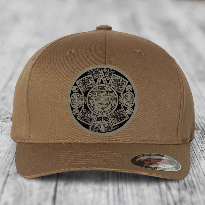 Tan baseball cap with Aztec calendar patch on front, featuring detailed black and white design.
