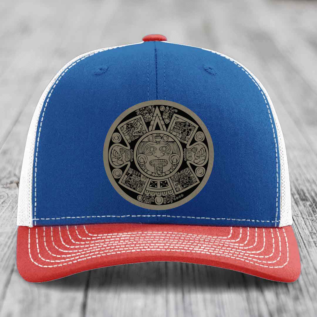 Blue and red trucker hat with Aztec calendar patch on front, white stitching, red button.