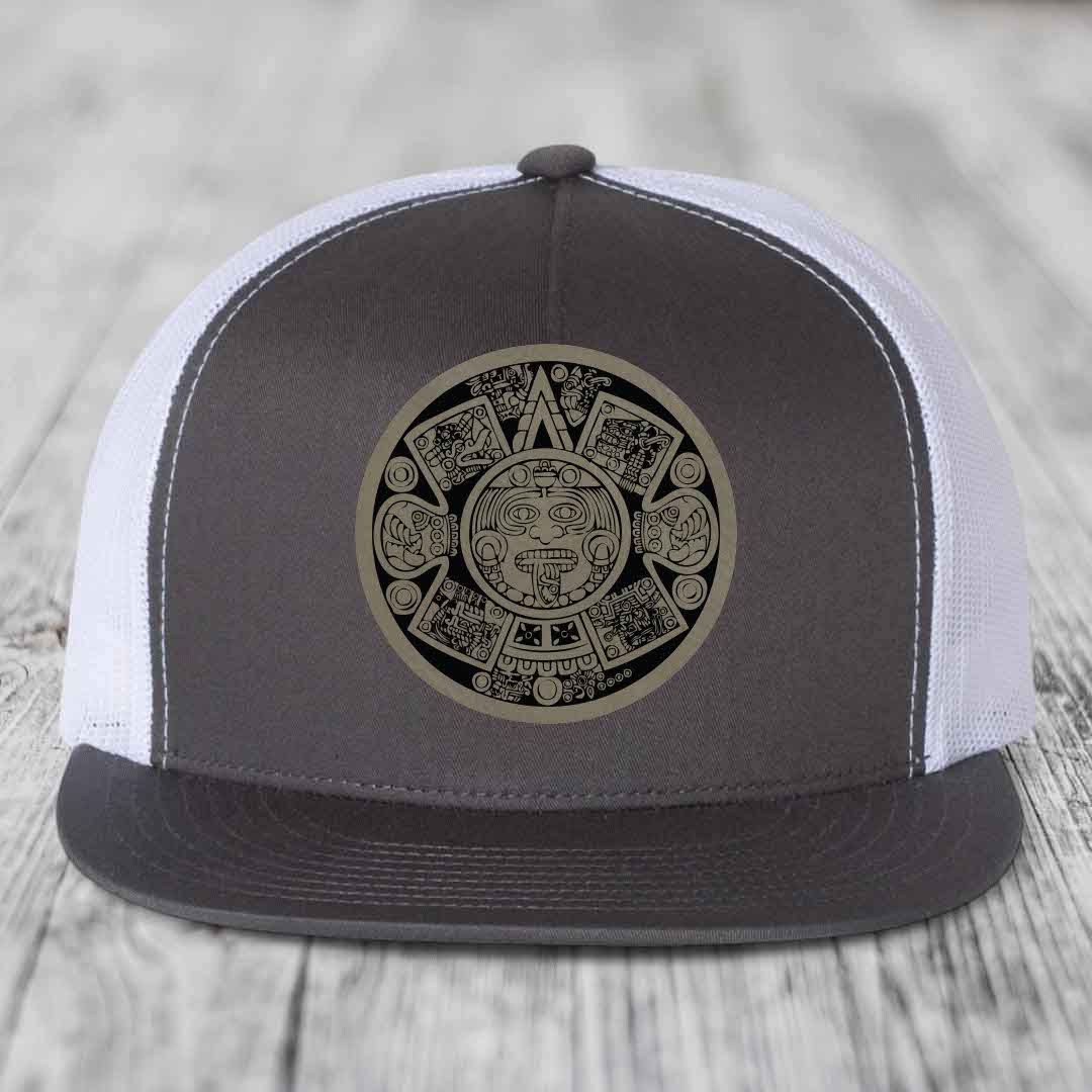 Grey and white trucker hat with Aztec calendar leather patch on front.