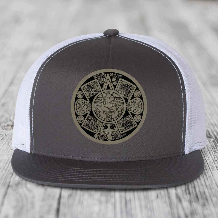 Grey and white trucker hat with Aztec calendar leather patch on front.