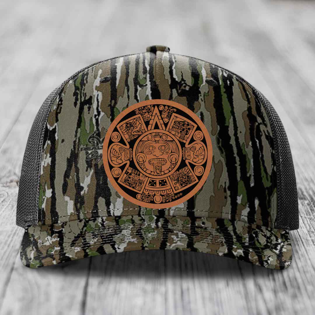 Camouflage trucker hat with brown Aztec calendar leather patch on front.