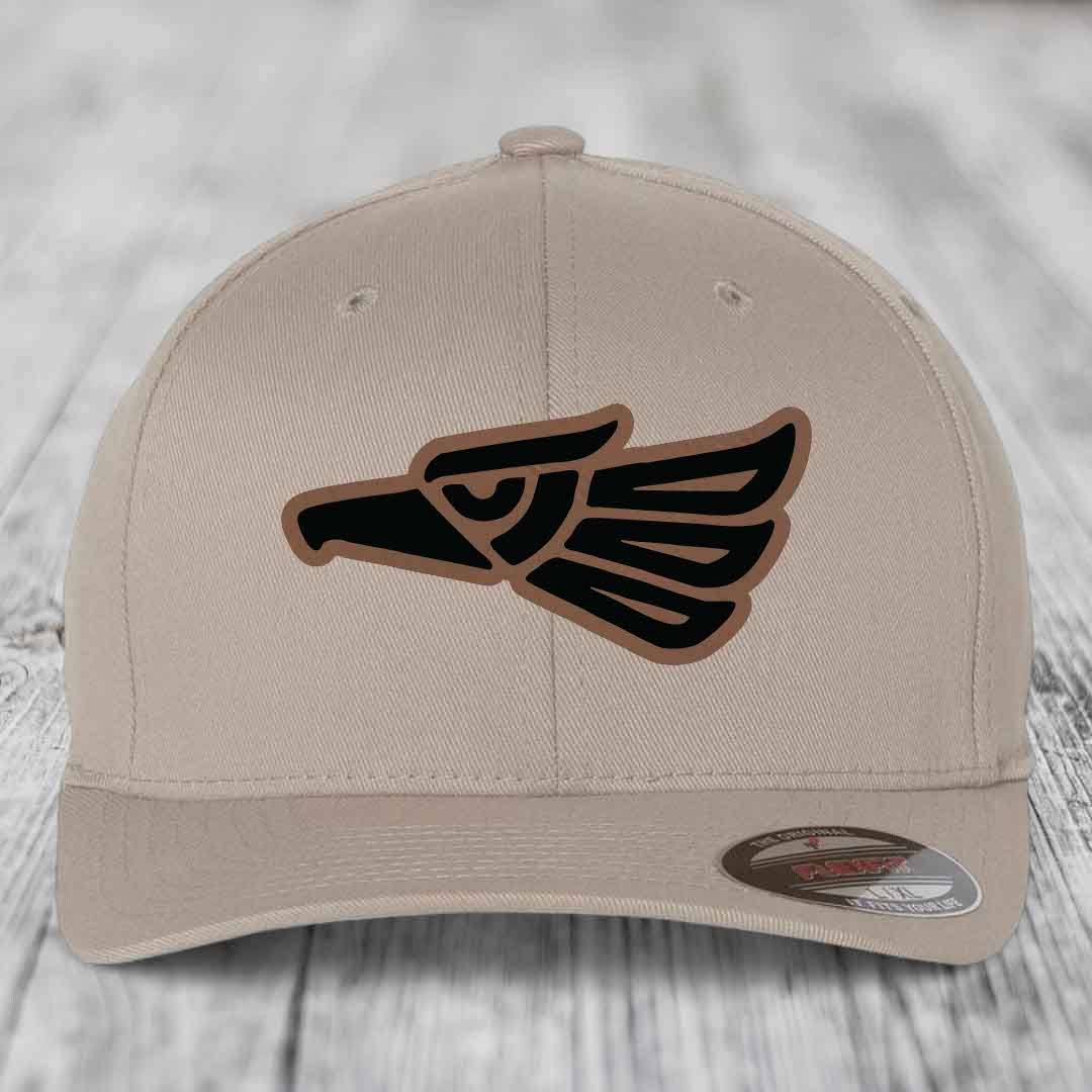 Beige baseball cap with Aztec-style eagle patch in black and brown.