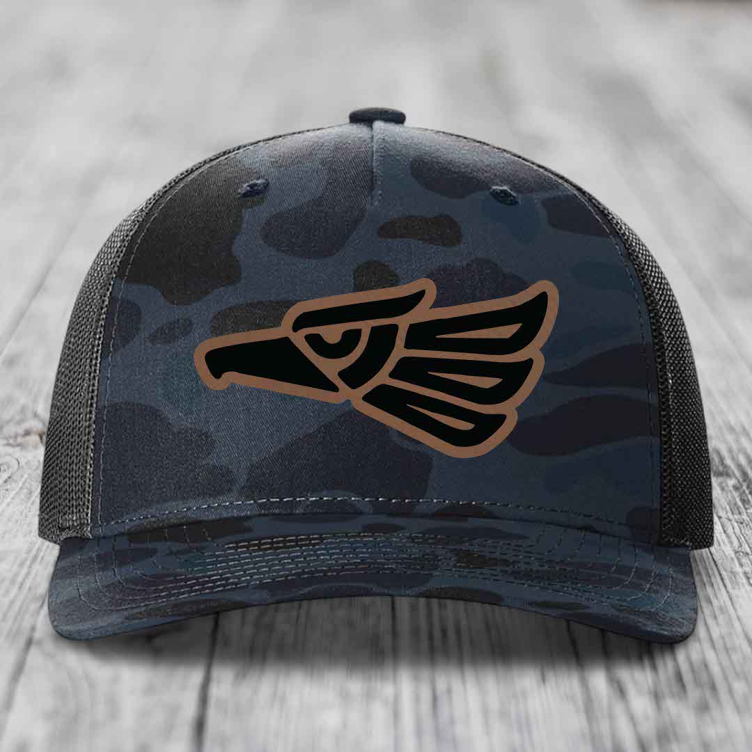 Camouflage trucker hat with Aztec eagle patch in black and brown.