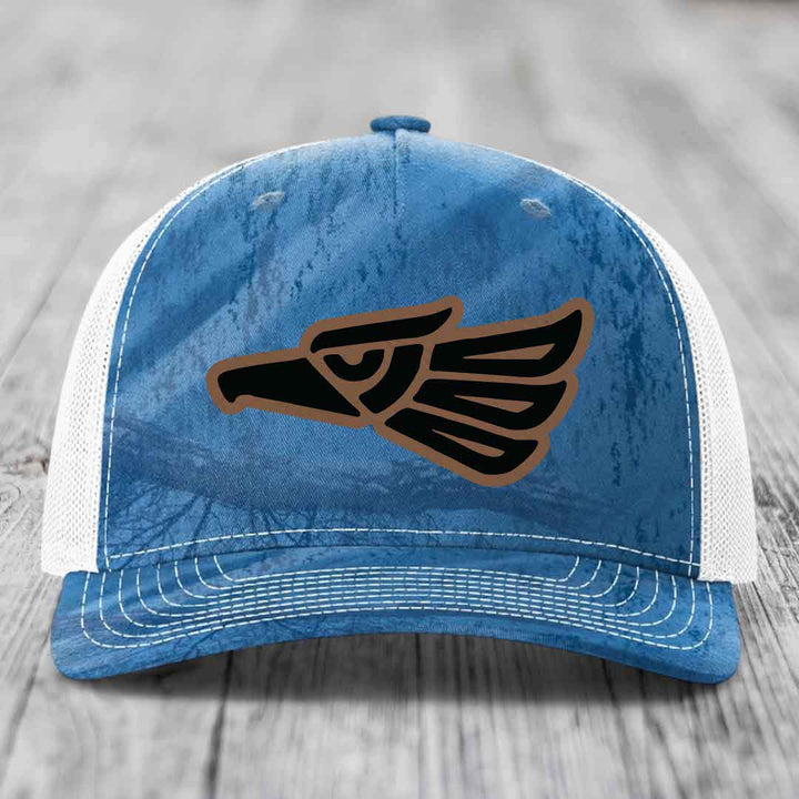 Blue and white trucker hat with an Aztec-style eagle patch on the front.