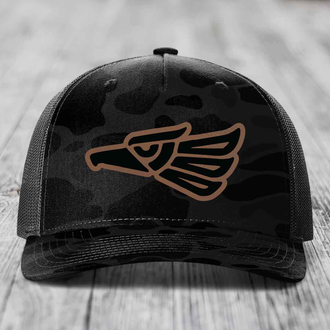 Black camouflage trucker hat with brown Aztec eagle patch on front.