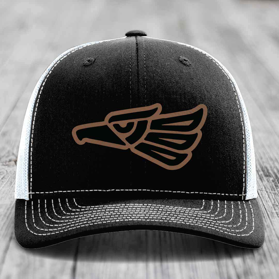 Black trucker hat with brown Aztec eagle patch and white stitching on front panel.