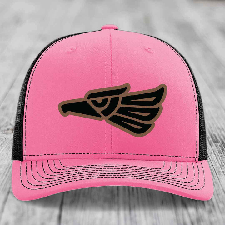 Pink trucker hat with black and brown eagle patch on front, black mesh back.
