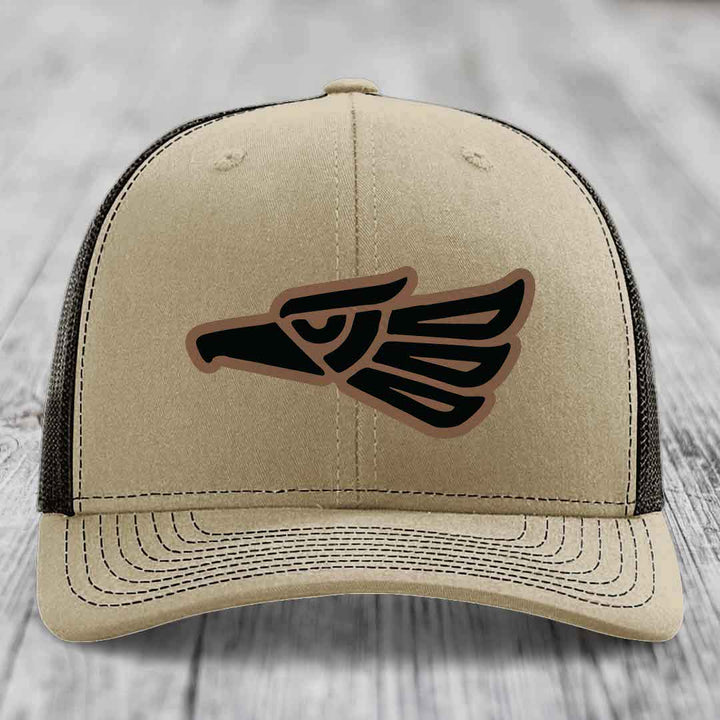 Beige trucker hat with black and brown Aztec eagle patch on front.