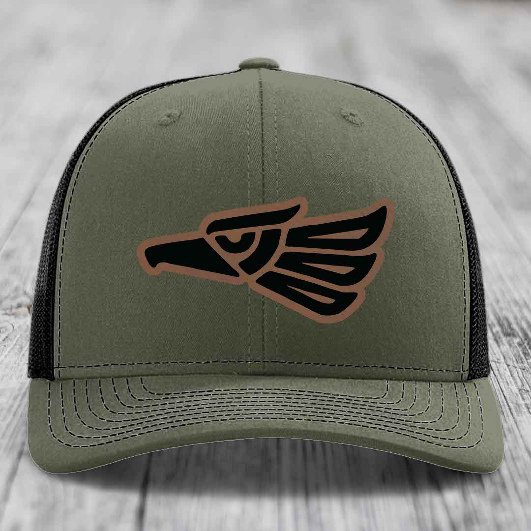 Olive green trucker hat with black and brown Aztec eagle patch on front.