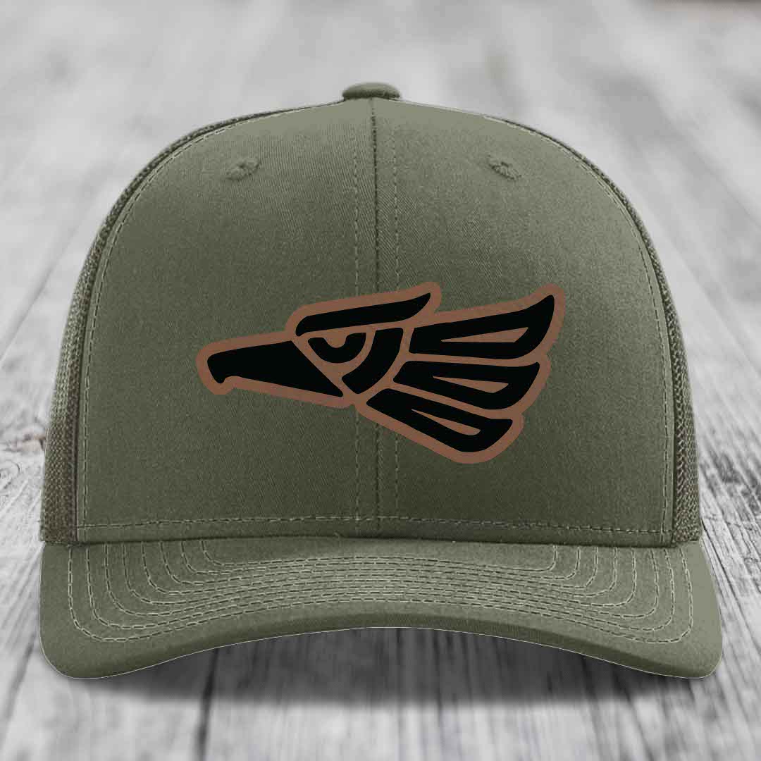 Olive green trucker hat with Aztec eagle leather patch on front.