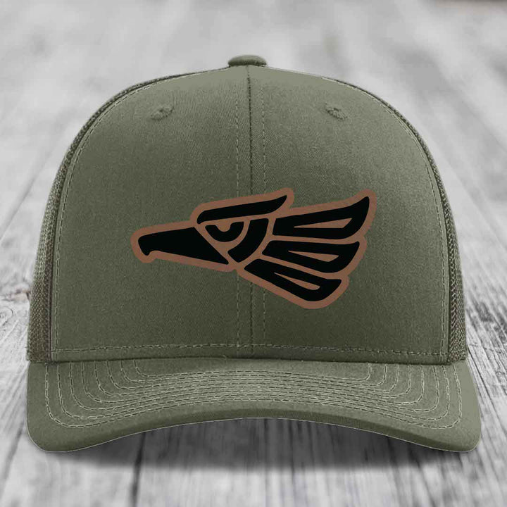 Olive green trucker hat with Aztec eagle leather patch on front.