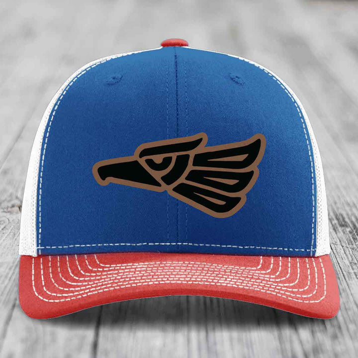 Blue and red trucker hat with embroidered eagle patch on front, white stitching, and red button.