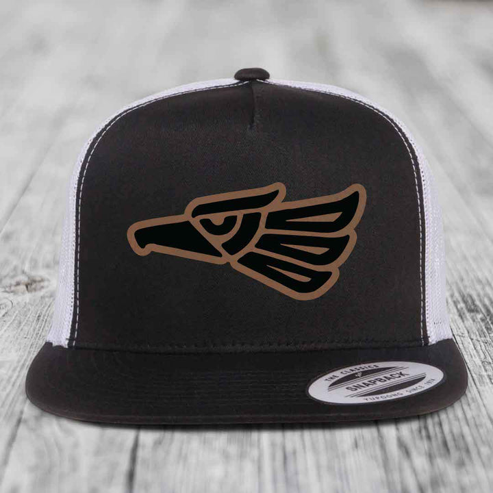 Black and white trucker hat with Aztec eagle leather patch on front.