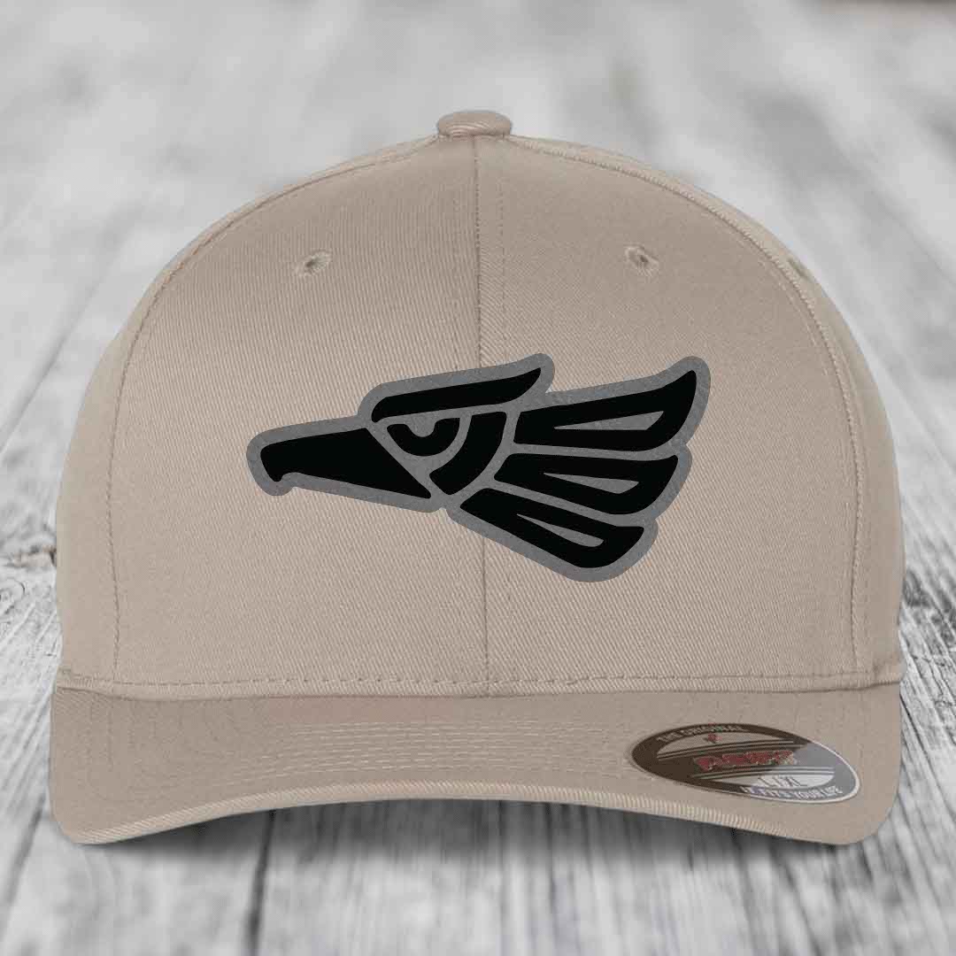 Beige baseball cap with black and grey Aztec eagle patch on front.