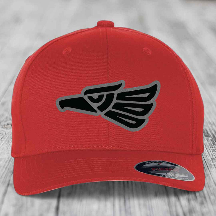 Red baseball cap with black and grey Aztec eagle patch on front.
