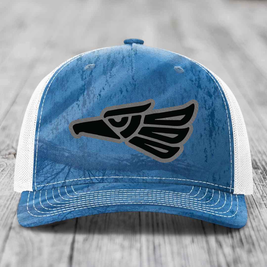 Blue and white trucker hat with a black Aztec-style eagle patch on the front.