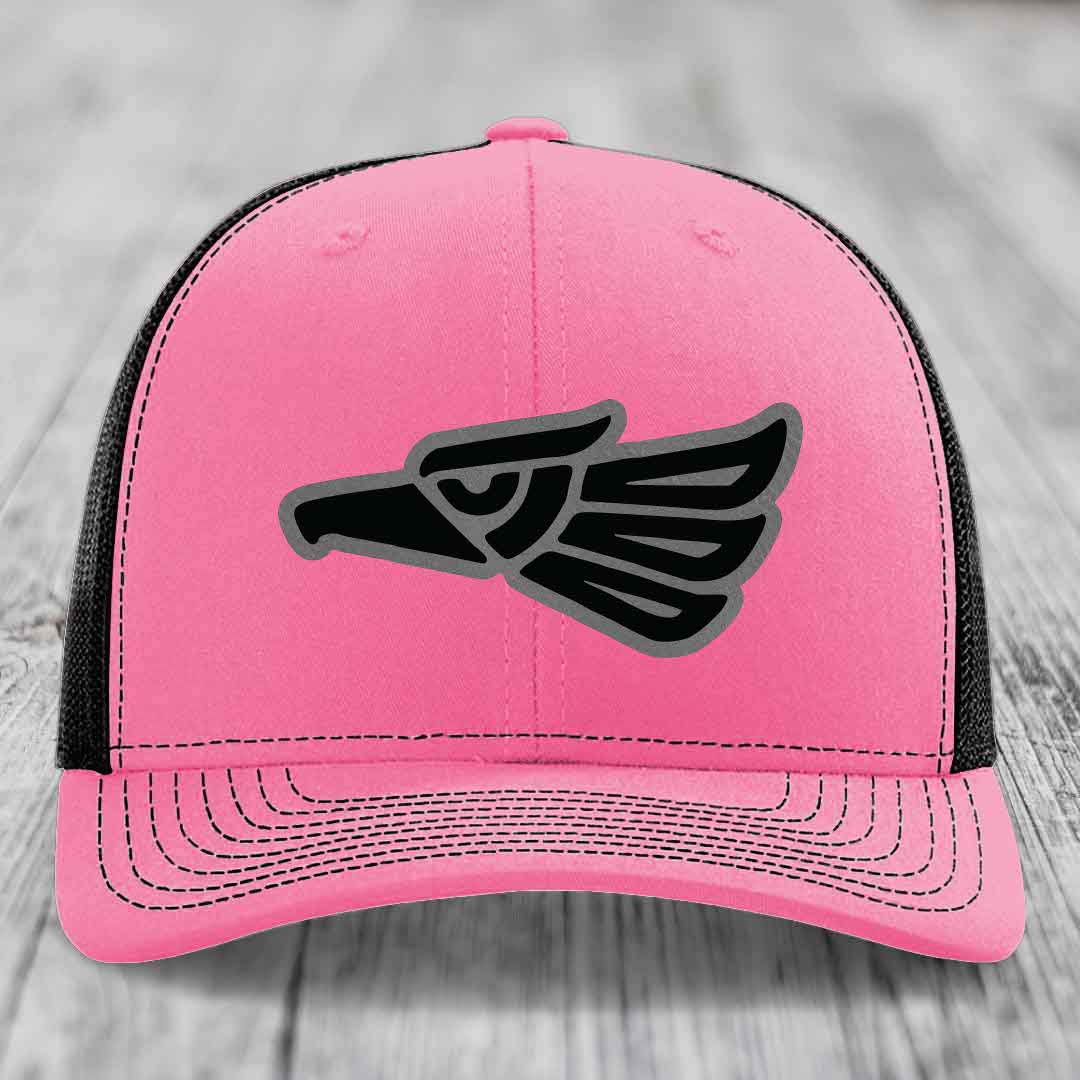 Pink trucker hat with black and grey eagle patch on front, black mesh back.