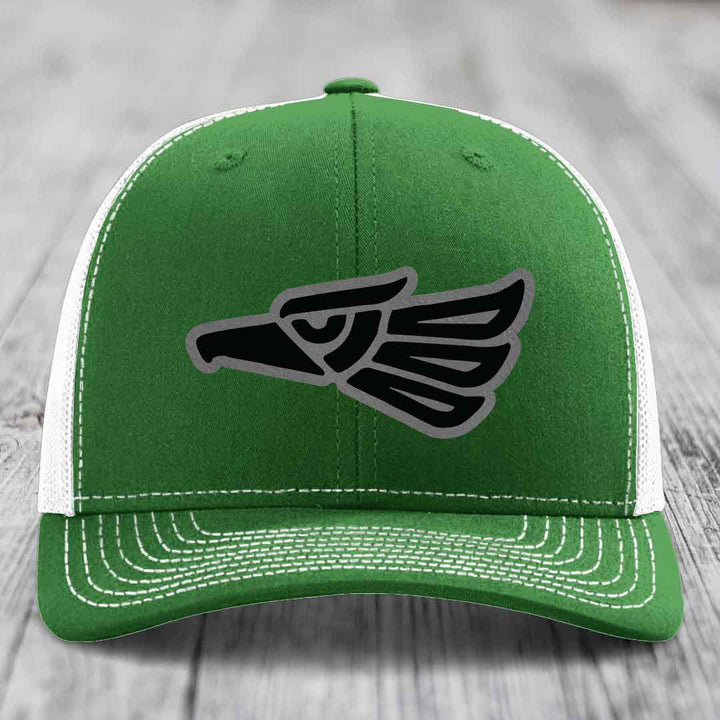 Green trucker hat with white mesh back and embroidered Aztec eagle patch.