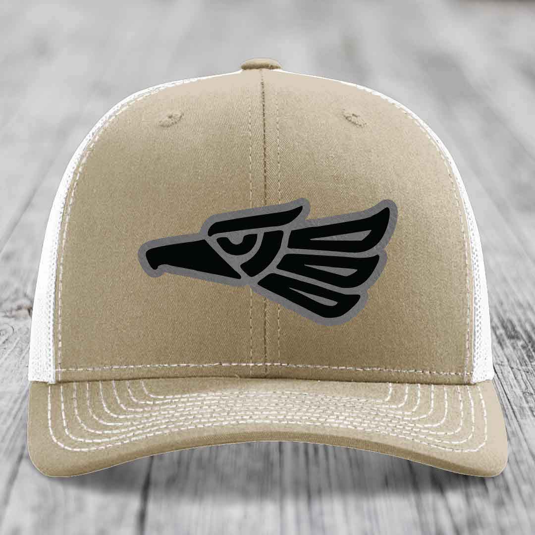 Tan trucker hat with black and grey Aztec eagle patch on front.