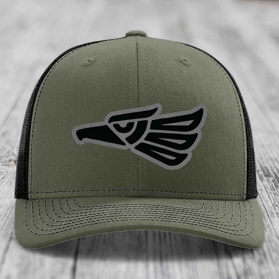 Olive green trucker hat with black and grey Aztec eagle patch on front.