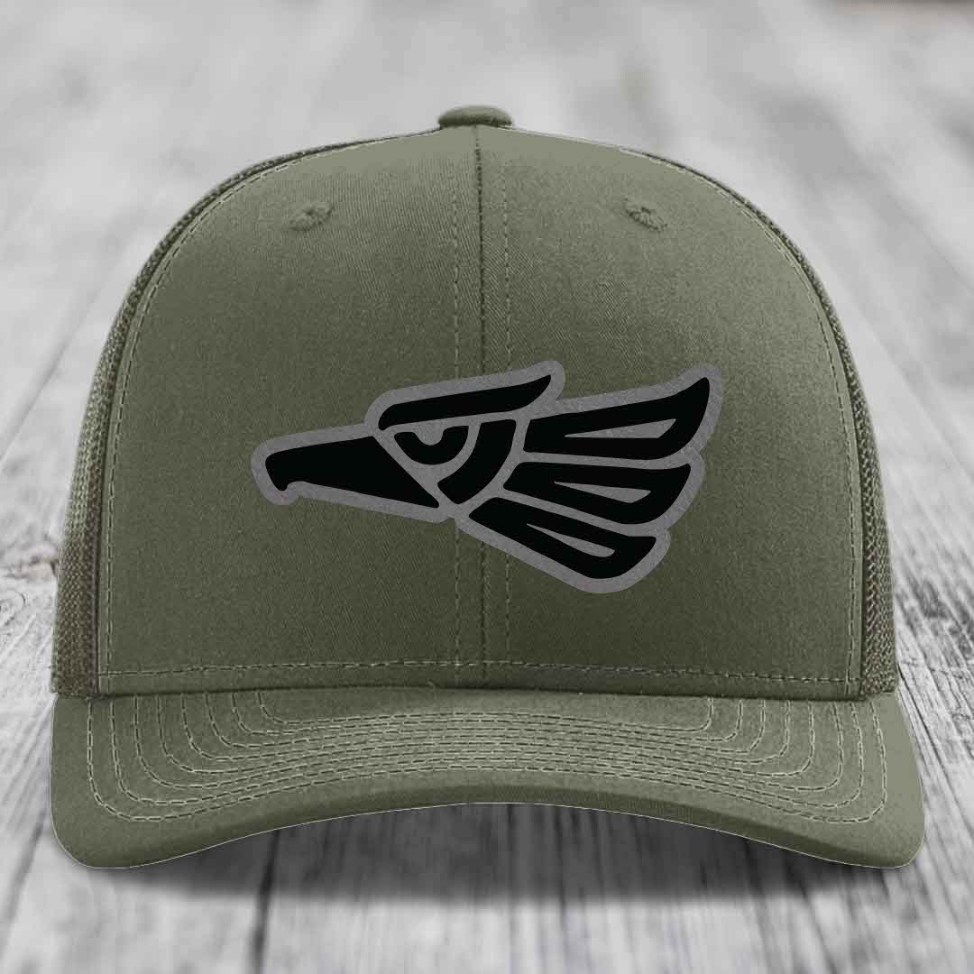 Olive green trucker hat with black and grey Aztec eagle patch on front.