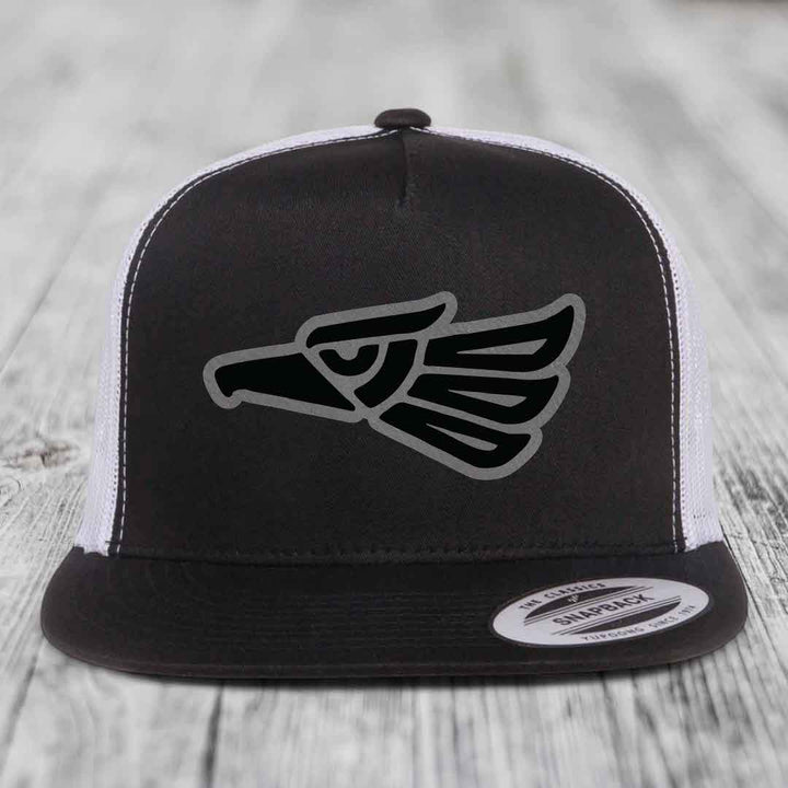 Black and white trucker hat with Aztec eagle patch on front.